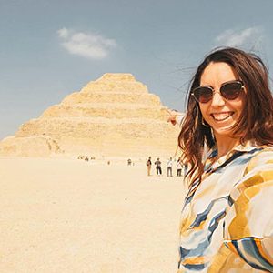 Tourist taking selfie with the step pyramid of djoser in saqqara egypt during her 13 day egypt and turkey grand tour