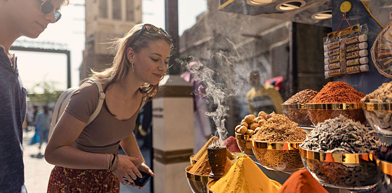 Tourists admiring the vibrant and aromatic spice stall in Deira Souq market Dubai