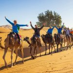 Tourists-riding-camels-in-the-desert-Merzouga-Erg-Chebbi-Sahara-Morocco