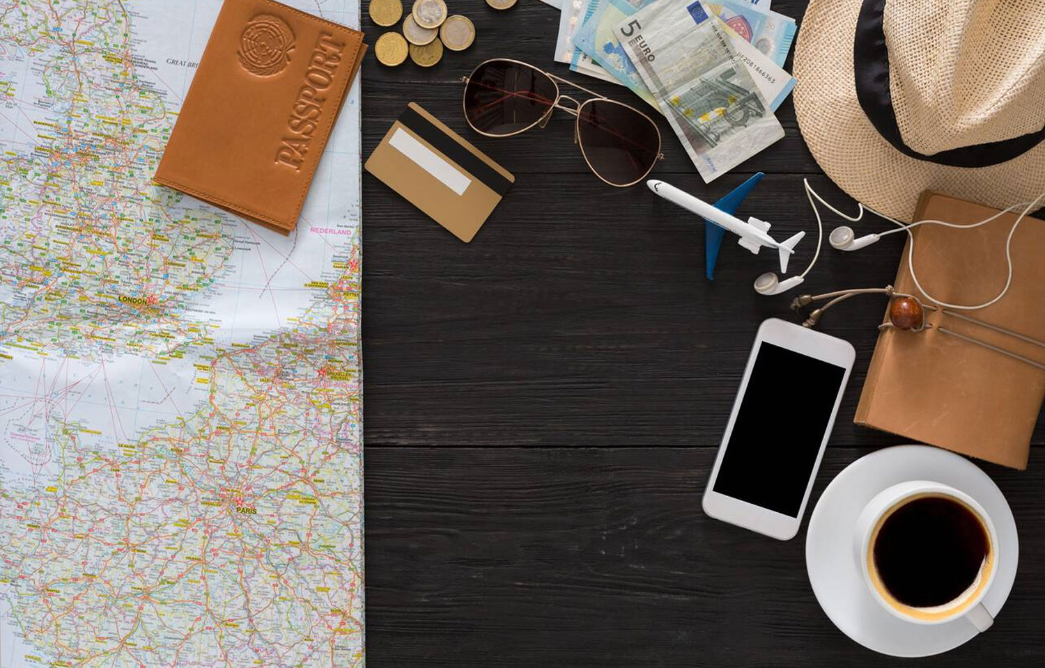 Travel Planning Includes A Map Passport Money Phone And Coffee On A Wooden Table