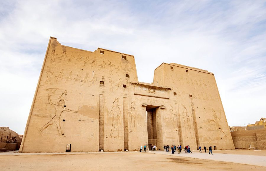 Tourists standing before the massive pylon of Edfu Temple an impressive stop on Upper Egypt Tours