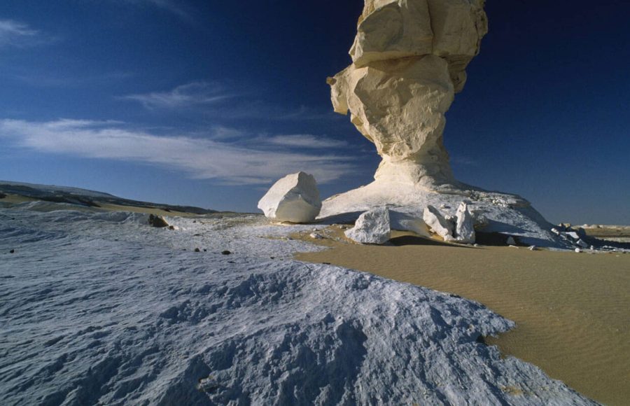A massive, white chalk mushroom rock formation stands in the White Desert Farafra at Western Desert Egypt, a key stop on western sahara desert tours.