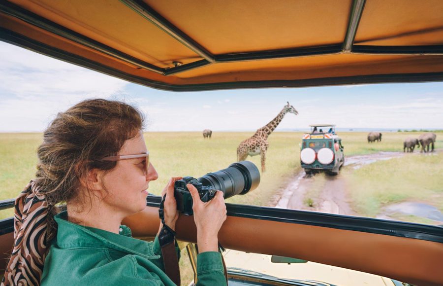 Woman-enjoying-safari-with-elephants-during-sunset-Maasai-Mara-National-Park,