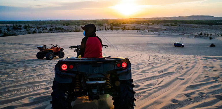 Young Man In Safari Trip Through Egyptian Desert Driving Atv At Sunset In The Desert Near Hurghada