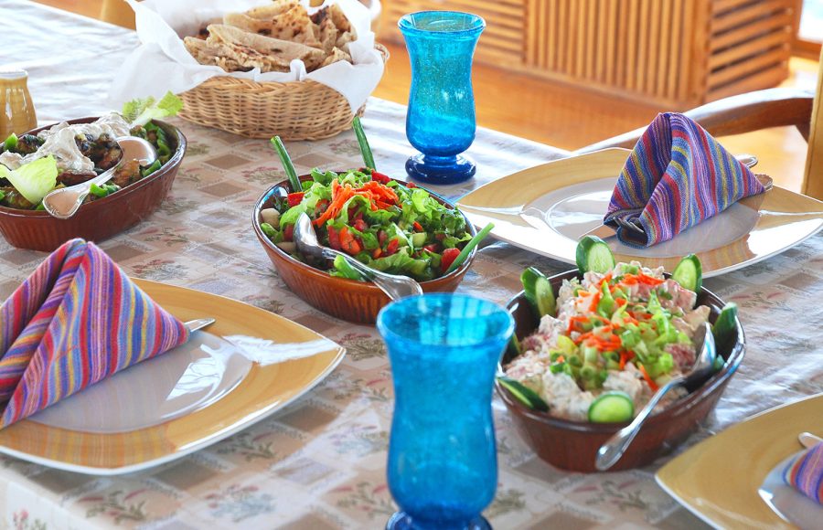 A table set with fresh Egyptian breakfast dishes including salads and flatbread.