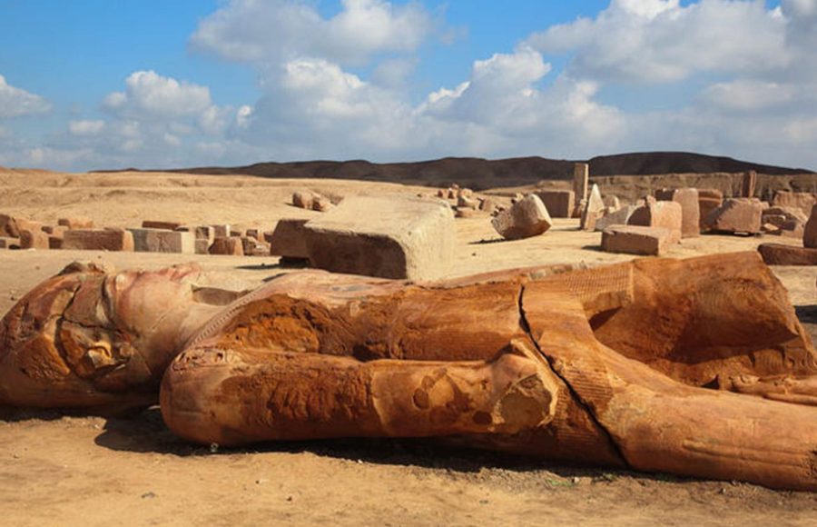 A massive, broken pharaonic statue lying among the blocks of the ancient Tanis ruins tour site