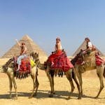 Three friends enjoying a scenic horseback ride pyramids adventure with the Great Sphinx in the distance