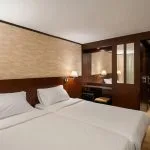 Comfortable twin bed cabin with dark wood and modern lighting on the Commodore Nile Cruise.