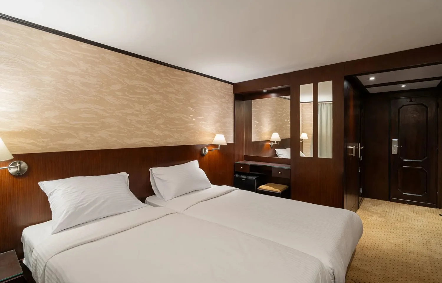 Comfortable twin bed cabin with dark wood and modern lighting on the Commodore Nile Cruise.