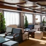 Spacious, well-lit lounge on the Nile Commodore cruise ship, furnished with modern armchairs.