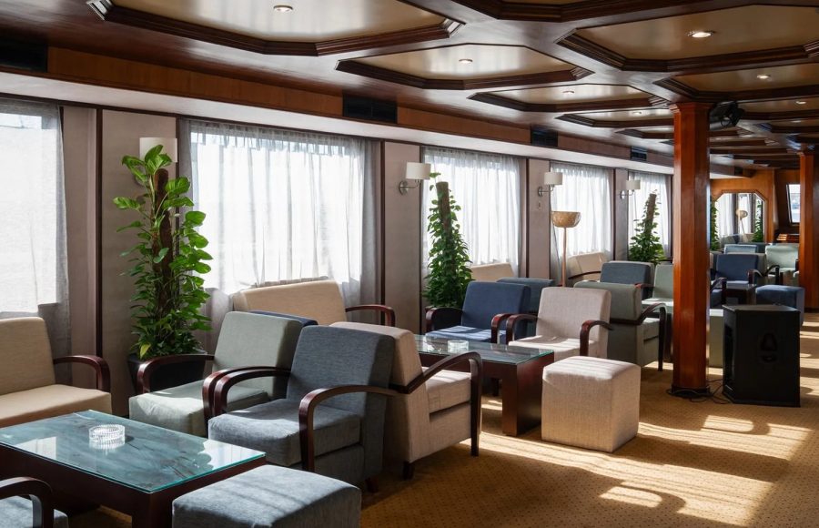 Spacious, well-lit lounge on the Nile Commodore cruise ship, furnished with modern armchairs.