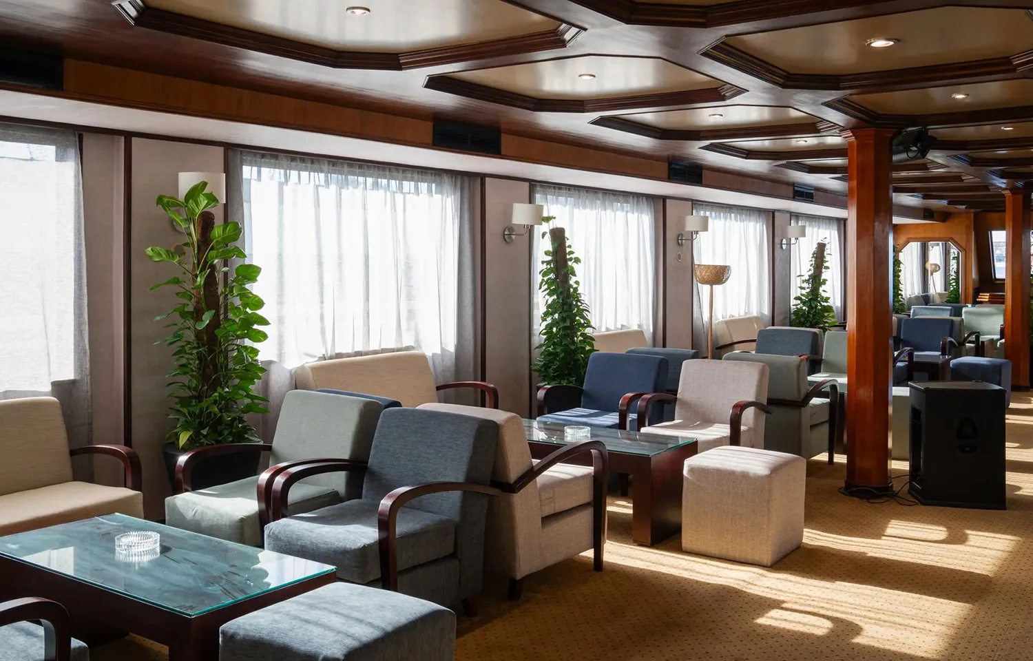 Spacious, well-lit lounge on the Nile Commodore cruise ship, furnished with modern armchairs.