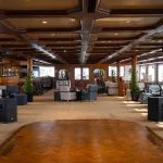 Spacious and richly decorated reception and Alt Text: Spacious, wood-paneled lounge and dance floor area on Alt Text: Large, elegant lounge and reception area with a wooden ceiling and seating on the MS Commodore Nile Cruise boat.