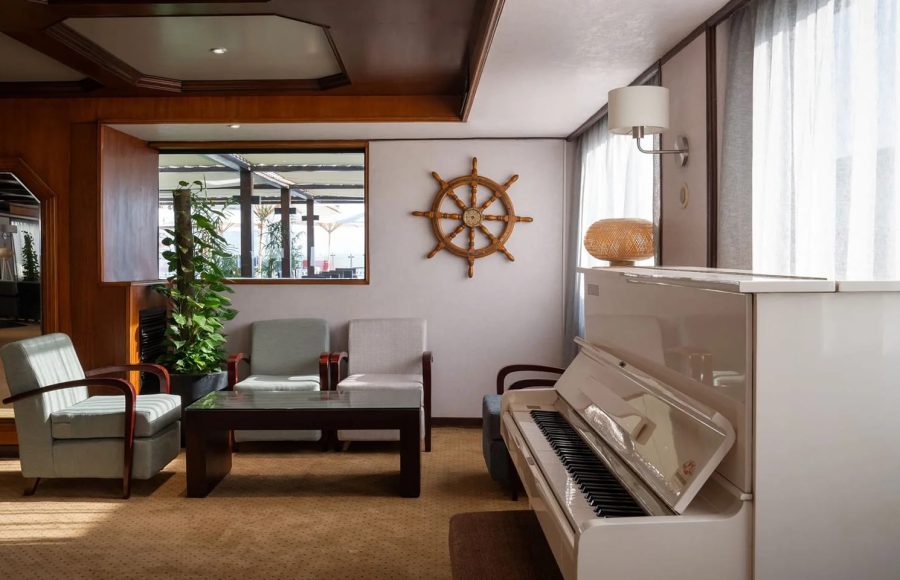 Ship-themed seating and piano lounge area on the MS Commodore Nile Cruise.