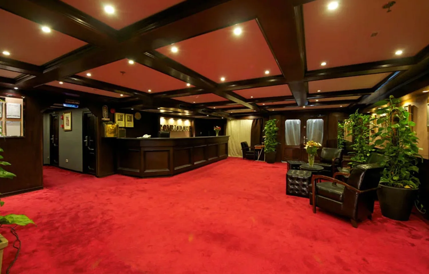Luxurious reception area with red carpet and wood paneling on the MS Commodore Nile ship.