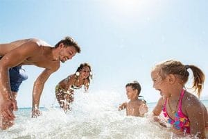 A happy family plays in the clear blue waters of the Red Sea, a perfect addition to a diverse 10 Days Egypt Itinerary.