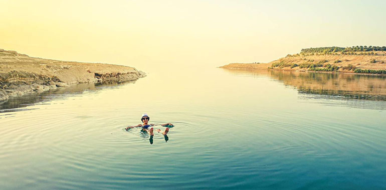 Female Tourist Float On Dead Sea Water Happy Enjoy Vacation In Jordan