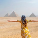 A female with long brown hair facing the three majestic Giza Pyramids in her 6 days Cairo and Hurghada Holiday.