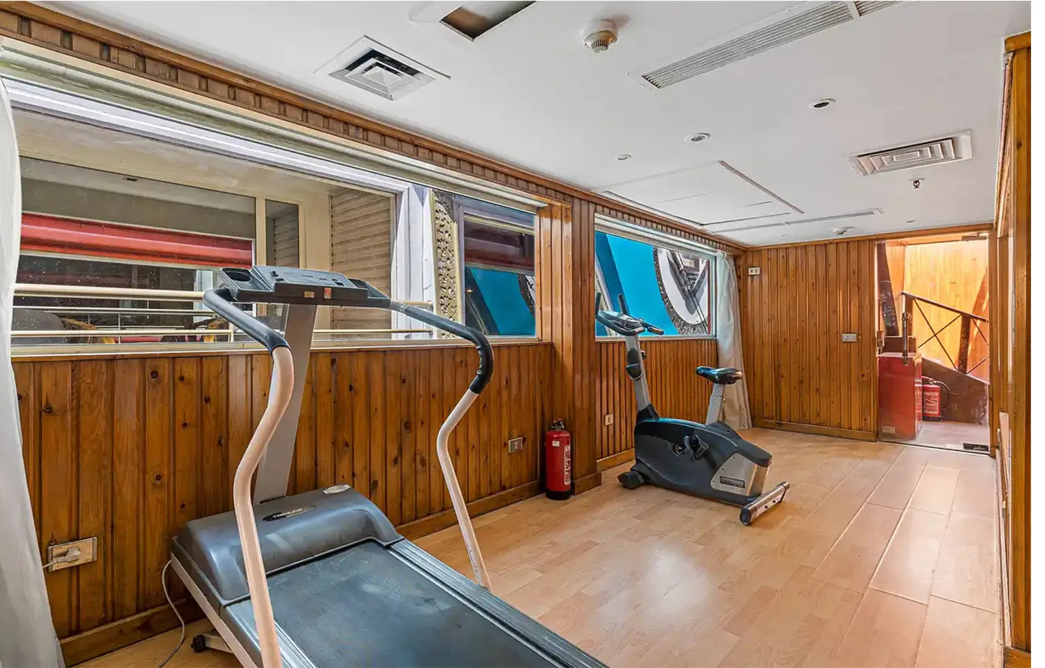 Small cruise ship gym with treadmill and exercise bike.