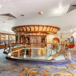 Nile cruise sundeck dining area with tables and river view.