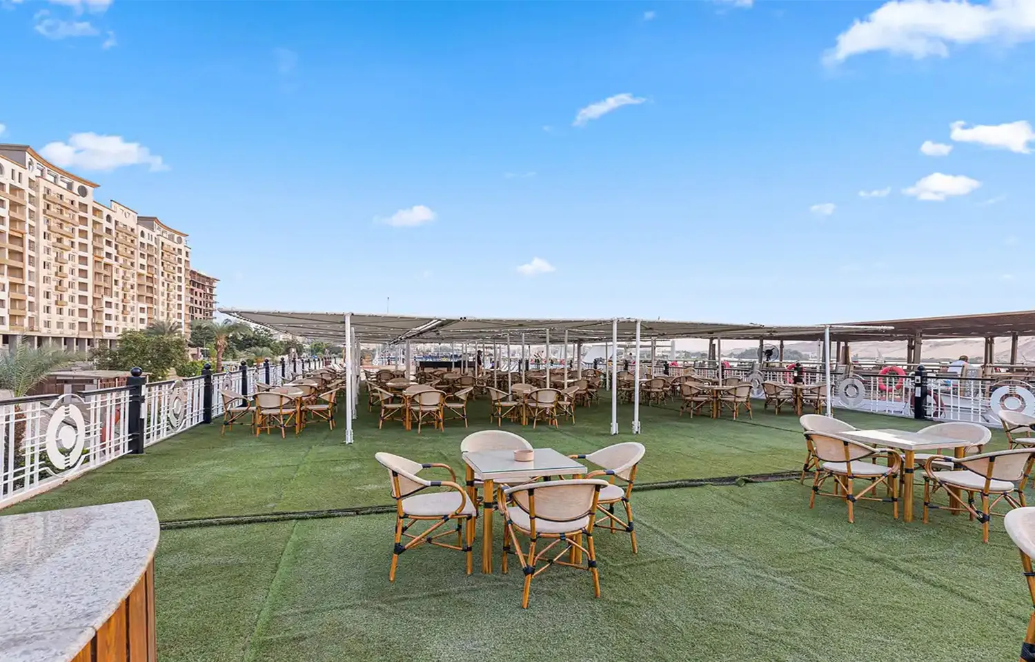 Nile cruise sundeck dining area with tables and chairs.