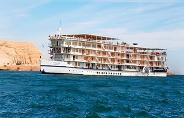 The Mövenpick Prince Abbas cruise ship sailing on deep blue water under a clear sky.