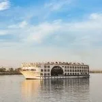 MS Farah Nile cruise ship sailing on the river, showing its distinct central arched window.