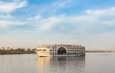 MS Farah Nile cruise ship sailing on the river, showing its distinct central arched window.