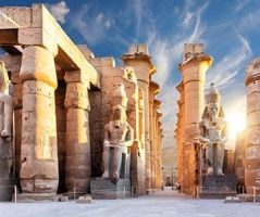 Grand columns and statues of Luxor Temple bathed in golden sunlight, an iconic ancient Egyptian landmark.