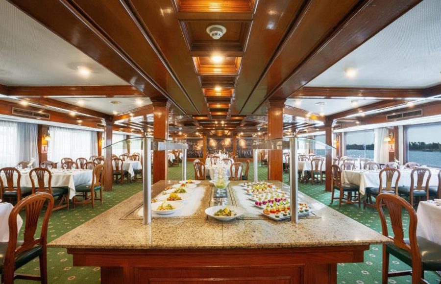 Buffet area in a cruise ship dining room with a granite food counter and displays of appetizers and salads.