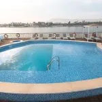 Rounded outdoor swimming pool on a Nile cruise ship deck with sun loungers.