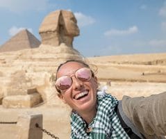 Woman taking a selfie at the Giza Pyramids and Sphinx during a 4 days Egypt itinerary.