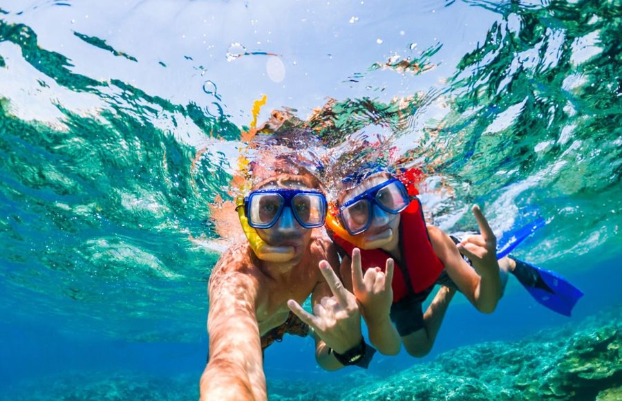 Two people wearing snorkeling masks and a life vest in clear turquoise water in their 6 days Cairo and Hurghada Holiday.