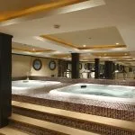 A luxury spa area on a ship featuring two built-in hot tubs and wooden step-up decking.
