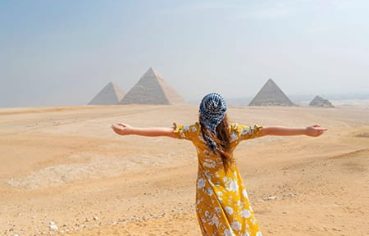 A tourist at the Great Pyramids of Giza, a highlight of the Cairo Luxor Aswan 8 day itinerary.