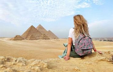 Tourist enjoying the view of the Great Pyramids of Giza during her best 14 day Egypt itinerary.