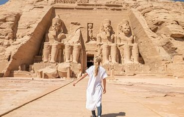 A traveler approaching the colossal statues at Abu Simbel, a key feature of the Cairo Luxor Aswan Alexandria Tour.