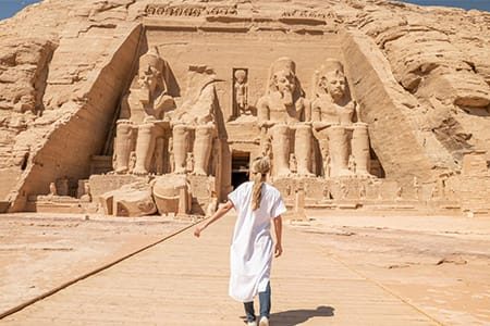 A Traveler Approaching The Colossal Statues At Abu Simbel, A Key Feature Of The Cairo Luxor Aswan Alexandria Tour.