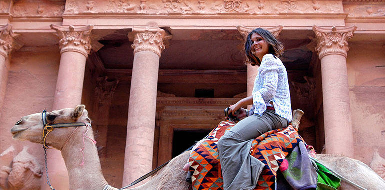 Woman Riding A Bedouin Camel And Smiling In Front Of The Treasury In Petra Jordan