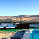 Sun deck with swimming pool and lounge chairs on the MS Zeina Nile Cruise ship, with desert hills in the background