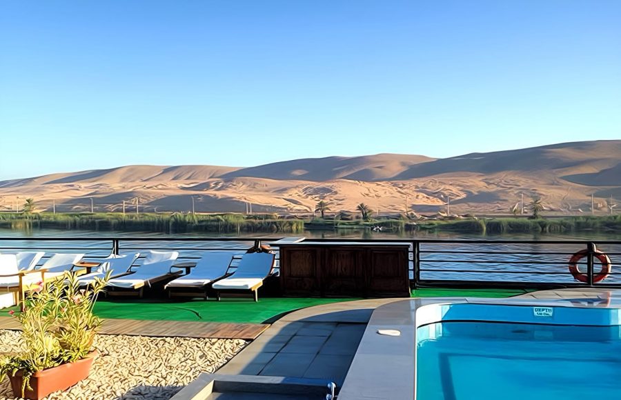 Sun deck with swimming pool and lounge chairs on the MS Zeina Nile Cruise ship, with desert hills in the background